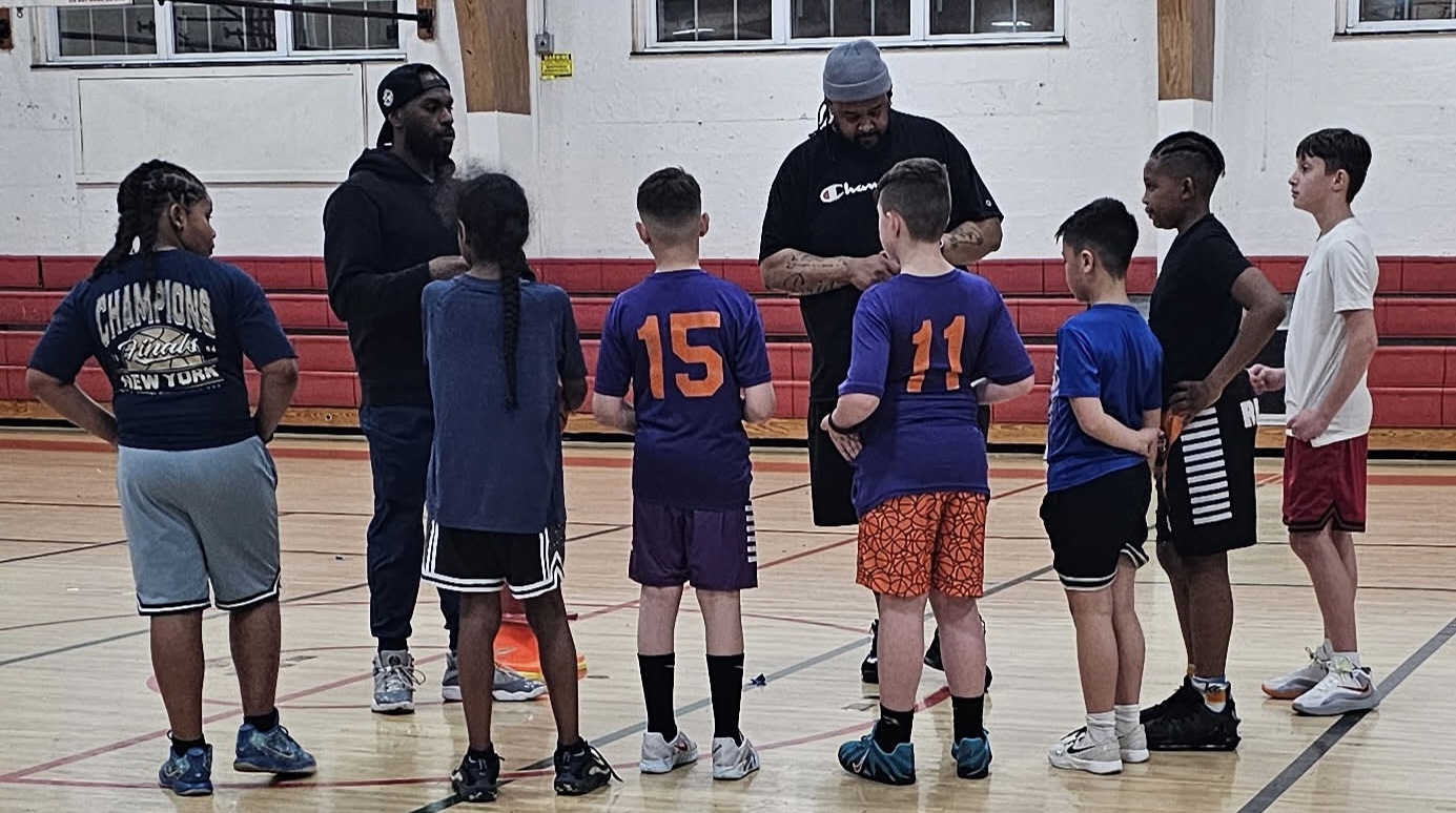 Coach Grace with youth players in a gym
